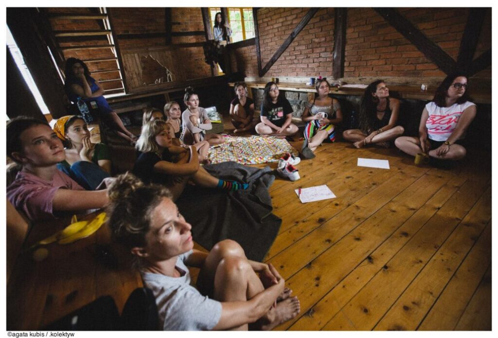 Grupa dziewczyn/kobiet w kręgu na drewnianej podłodze